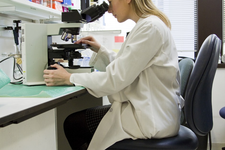 An embryologist examining samples under a microscope in a fertility laboratory