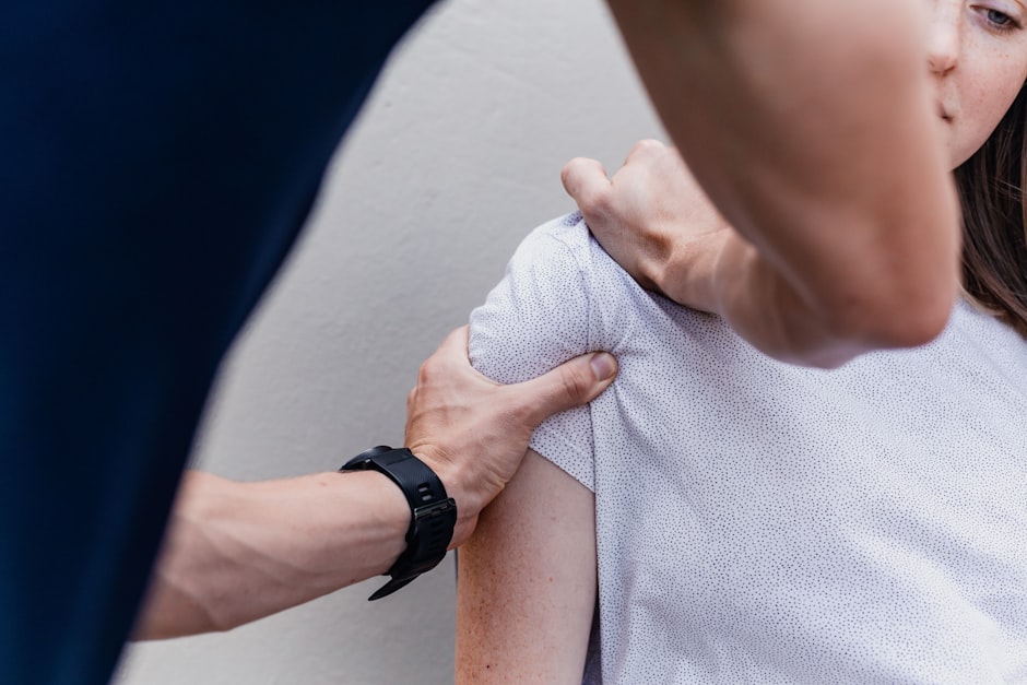 A clinician examining a patient's shoulder before shoulder replacement surgery