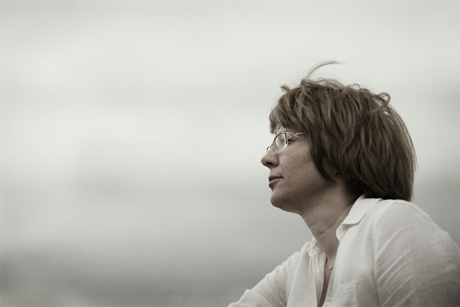 A woman in profile looking into the distance, her jawline and neck visible