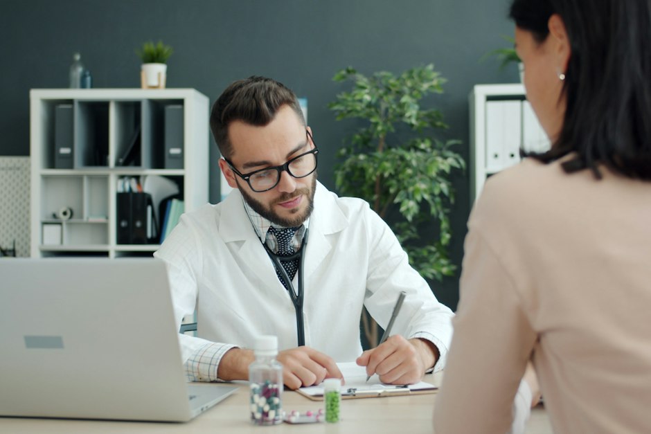 A woman in a consultation with a doctor who is taking notes