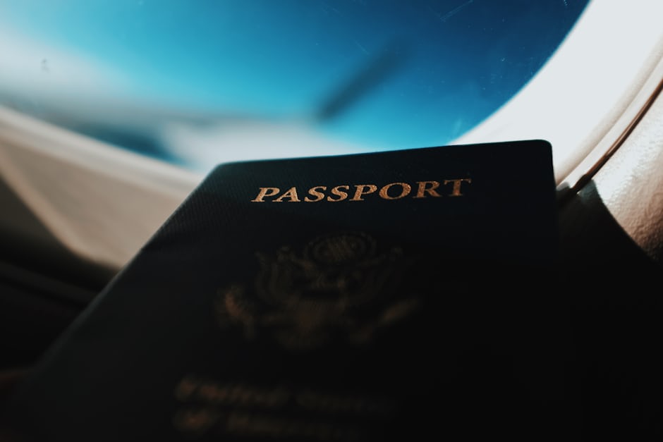 A passport held against an aircraft window, representing travelling abroad for medical treatment